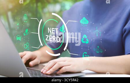 La femme utilise un ordinateur portable avec l'icône de réduction de carbone environnementale ou la technologie zéro nette. neutralité carbone. Empreinte carbone, émissions de CO2, durable Banque D'Images