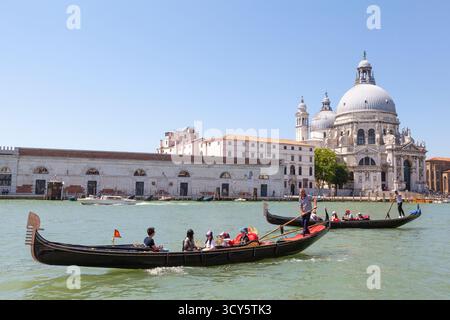 Touristes asiatiques appréciant la balade en gondole passant Basilica di Santa Maria della Salute, Grand canal, Venise, Italie, tourisme, voyages d'été Banque D'Images