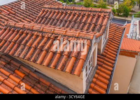 Une photo en gros plan à grand angle met en valeur les tuiles en terre cuite texturées et altérées d'un toit traditionnel, mettant en valeur son caractère vieilli et sa tapisserie complexe Banque D'Images