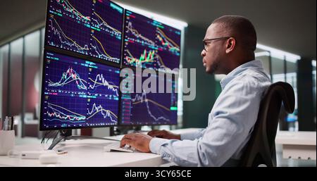 Homme afro-américain travaillant comme courtier en actions au bureau Banque D'Images