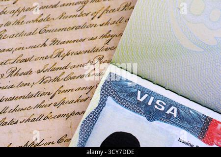Vue rapprochée d'un visa américain estampillé sur une page de passeport avec fond de Constitution américaine. Concept de voyage et d'immigration Banque D'Images