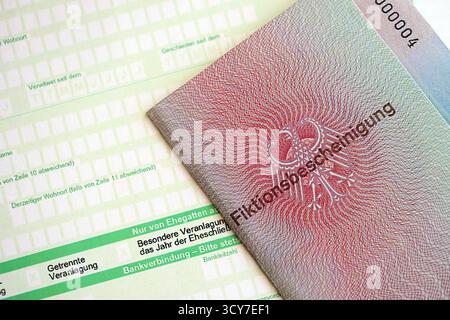 Le spécimen de carte de résident permanent temporaire allemand se trouve sur le formulaire fiscal allemand close up. Fiktionsbescheinigung et einkommensteuerklarung Banque D'Images