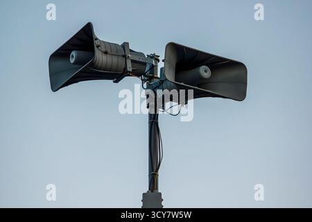 Haut-parleur moderne d'avertissement de raid aérien monté sur un poteau métallique, utilisé pour la diffusion d'alertes d'urgence, de signaux d'avertissement et d'annonces de sécurité publique. Banque D'Images