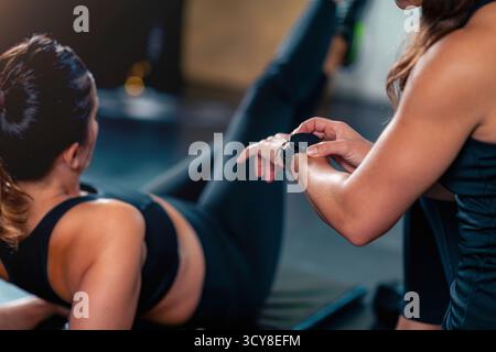 Entraîneur de fitness personnel encadrant une femme dans le gymnase. Banque D'Images