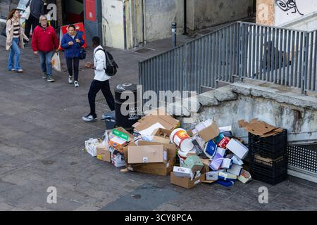 Une grande pile de boîtes en carton et diverses ordures est abandonnée sur un coin de rue urbaine près des marches et une balustrade en métal créant une scène de déc. Urbain Banque D'Images