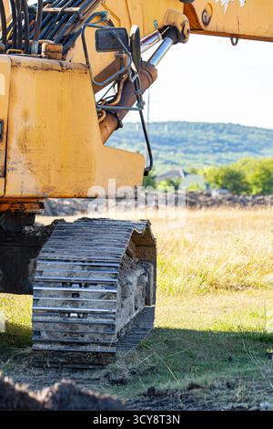 Excavatrice avec godet Lift Up creusent le sol dans le chantier de construction sur le fond du ciel Banque D'Images