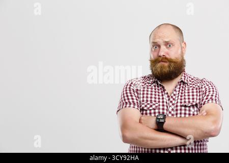 Homme perplexe avec la barbe de gingembre sur fond gris vide, place pour l'inscription Banque D'Images