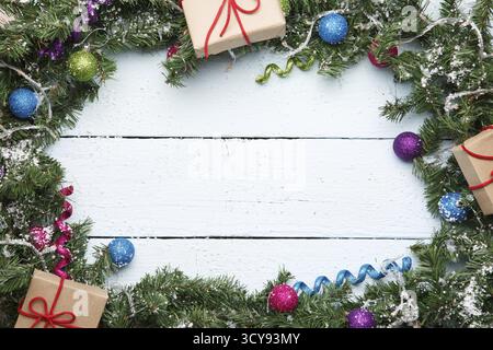 Branches de sapin de Noël avec des cadeaux sur fond en bois Banque D'Images