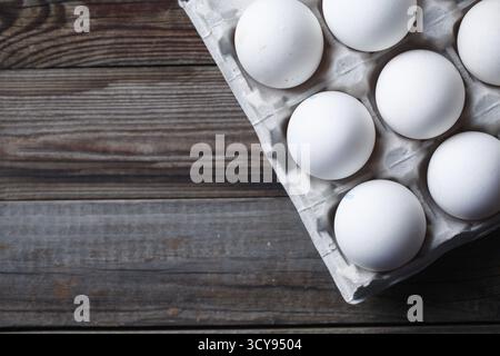Oeufs blancs sur une table en bois rustique. Vue de dessus Banque D'Images