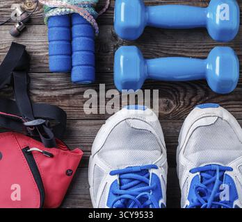Chaussures et équipement de sport sur un sol en parquet, vue du dessus Banque D'Images