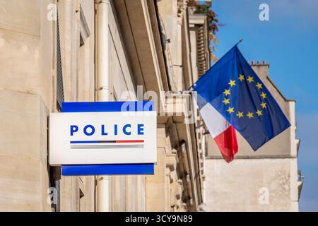 "POLICE" écrit sur le panneau d'un commissariat de police à côté des drapeaux français et européens. Notions de criminalité, d'enquête et d'intervention policière en France Banque D'Images