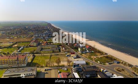 Vagues baltes lisses près de Sarbinowo sous la lumière du soleil, large plage et horizon vus depuis le drone. Banque D'Images