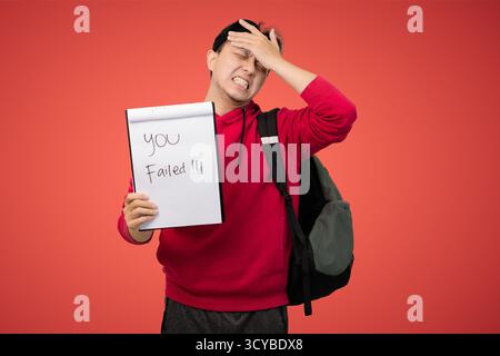 jeune homme dans le sweat à capuche rouge tient signe de lecture vous avez échoué, surpris et déçu expression Banque D'Images