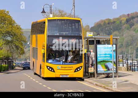 Dartmouth, Devon, Angleterre, Royaume-Uni - 24 avril 2025 : les gens prennent un bus à impériale exploité par Stagecoach à un arrêt de bus dans la ville de Dartmouth. Banque D'Images