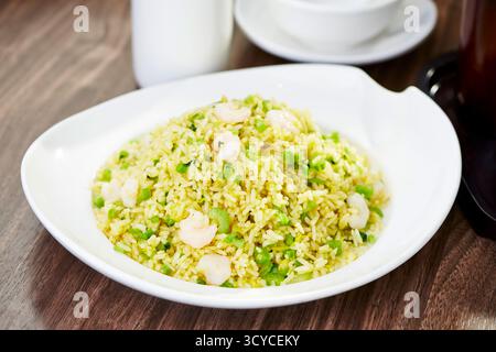 Riz frit classique du vieux Shanghai avec crevettes et légumes verts servis dans une vue latérale de plat traditionnel chinois Banque D'Images