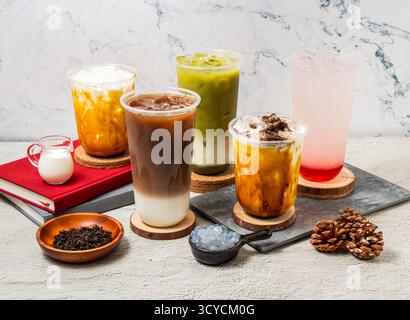 Assortiment de thés glacés Taïwan Oolong Milk Latte, Green tea Latte, Strawberry Lemon tea, Ice Oreo Milk tea, servi dans un verre jetable isolé à bord du sid Banque D'Images