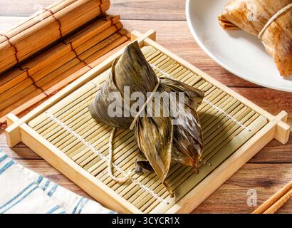 Zongzi vapeur méridionale en feuille de bambou isolé sur la vue latérale mate de la nourriture de taiwan Banque D'Images