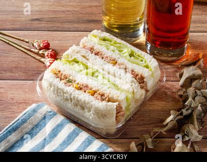 Sandwich au thon avec laitue servi dans une boîte jetable isolé sur la table en bois vue de côté de la nourriture taïwanaise Banque D'Images