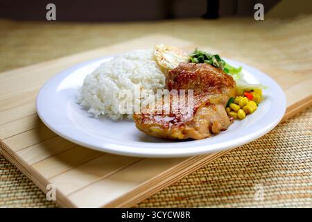 Côtelette de poulet aux échalotes avec riz, omelette aux œufs et sauce sou servie dans une assiette isolée sur la table vue en gros plan de la nourriture de Hong Kong Banque D'Images