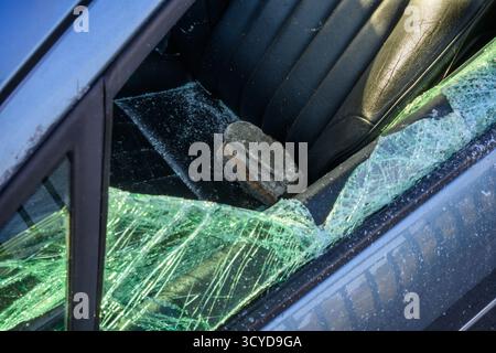 UK car crime - Un rocher se trouve sur le siège passager d'Une voiture ayant été utilisé par des voleurs pour briser la fenêtre pour accéder à Kirkliston, Édimbourg, Écosse Banque D'Images
