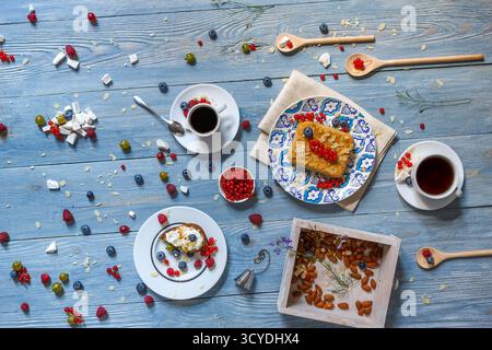 Petit déjeuner avec pois et baies au bois rustique bleu Banque D'Images