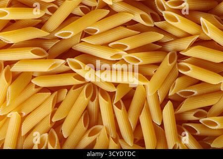 Pâtes Penne brutes en forme de tube avec texture organique vue de dessus Banque D'Images