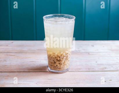 Rafraîchissant eau d'orge glacée avec glaçon servi dans un verre isolé sur fond en bois vue latérale de Hong Kong boisson Banque D'Images