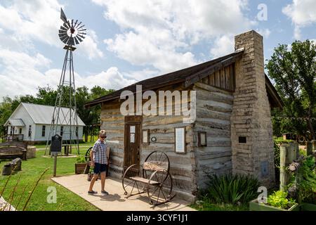Une femme se tient au palais de justice original du comté de Johnson, qui fait maintenant partie du Chisholm Trail Outdoor Museum près de Cleburne, Texas, États-Unis. Banque D'Images