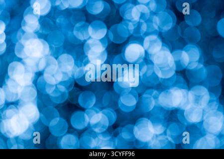 Bokeh bleu clair et blanc sur fond noir – fond abstrait de vacances du nouvel an avec guirlande lumineuse défocalisée Banque D'Images