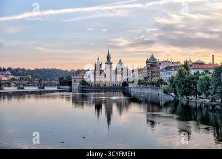 Vue matinale sur la rivière Vltava vers les tours historiques et les bâtiments de la vieille ville de Prague, République tchèque, avec des reflets dans l'eau calme. Banque D'Images