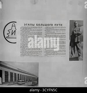Cette photo d'archives en noir et blanc des années 1970 à Sloviansk, URSS (RSS d'Ukraine), montre une diffusion imprimée sur l'armature-isolant de Slavyansk (AIZ). Cette publication, probablement un journal d'usine, contient un grand article intitulé « étapes d'un long voyage » (« Etapy Bolshogo puti ») détaillant l'histoire de l'usine. La mise en page comprend également le logo officiel 'AIZ', une photographie d'un long atelier d'usine et une photo d'un monument révolutionnaire. Cette image horizontale est un document précieux de la fierté industrielle soviétique Banque D'Images