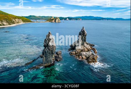 Superbe paysage côtier au lever du soleil avec des formations rocheuses distinctes et des eaux océaniques claires Banque D'Images