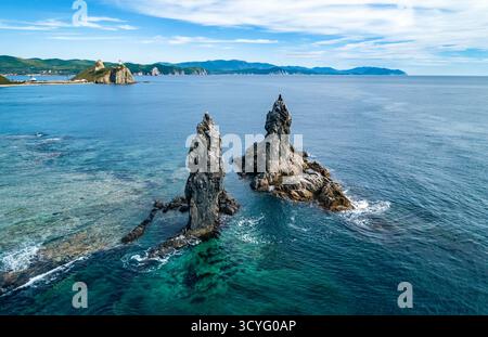 Superbe paysage côtier au lever du soleil avec des formations rocheuses distinctes et des eaux océaniques claires Banque D'Images
