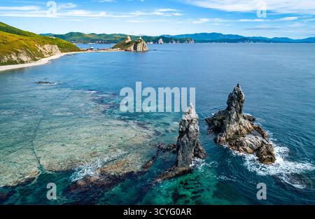 Superbe paysage côtier au lever du soleil avec des formations rocheuses distinctes et des eaux océaniques claires Banque D'Images