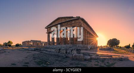 La lumière dorée du soir baigne les anciens temples grecs de Poséidon et Hera à Paestum, Campanie, Italie. Les tons chauds du coucher de soleil soulignent le Dor Banque D'Images
