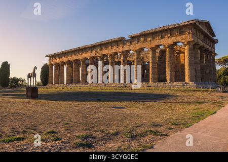 La lumière dorée du soir baigne les anciens temples grecs de Poséidon et Hera à Paestum, Campanie, Italie. Les tons chauds du coucher de soleil soulignent le Dor Banque D'Images