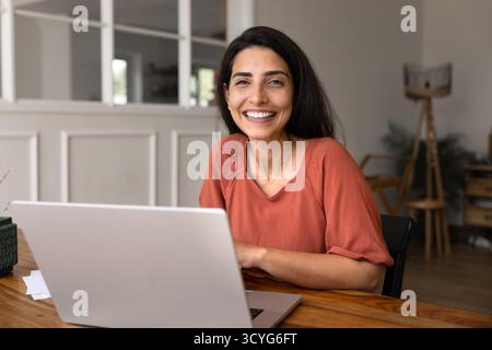 Heureuse jeune femme professionnelle indépendante hispanique posant pour le portrait Banque D'Images