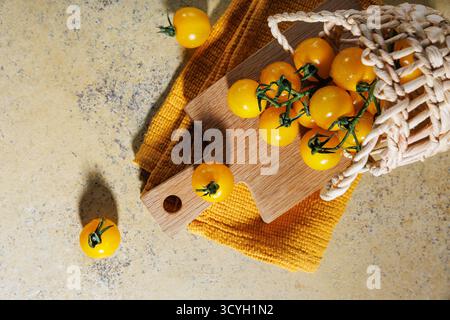 Plan au-dessus de tomates rustiques dans un panier sur une serviette jaune Banque D'Images