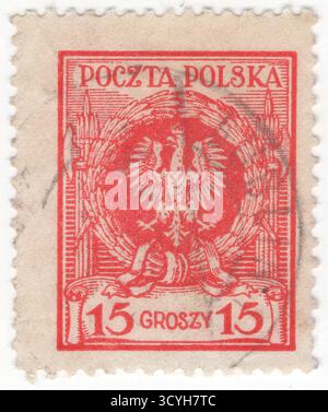 POLOGNE — 1er mai 1924 : timbre-poste rouge à 15 grosz représentant un aigle polonais couronné dans une couronne de laurier et des fasces, l'élément principal des armoiries de la Pologne indépendante. Les armoiries de la Pologne sont un aigle blanc couronné avec un bec doré et des talons, sur un fond rouge. En Pologne, les armoiries dans leur ensemble sont appelées godło dans les documents officiels et les discours familiaux, malgré le fait que les autres armoiries sont généralement appelées une herbe. Cela provient du fait que dans l'héraldique polonaise, le mot godło signifie seulement une charge héraldique Banque D'Images