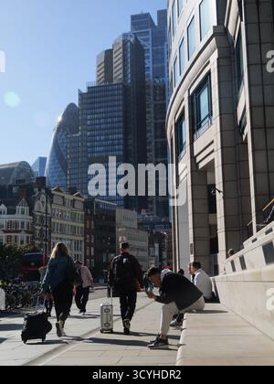 Les gens s'assoient sur des marches en béton conçues comme un coin salon public à l'extérieur de Broadgate tandis que les piétons montent Bishopsgate London en direction des gratte-ciel de la City de Londres au Royaume-Uni Banque D'Images