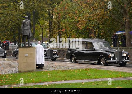 Le cortège funéraire de l'ancien juge-arbitre Harold 'Dickie' Bird, décédé en septembre à l'âge de 92 ans, passe devant sa statue de bronze grandeur nature, alors qu'elle se dirige vers son service funéraire à l'église St Mary's voisine, à Barnsley. Date de la photo : dimanche 19 octobre 2025. Banque D'Images