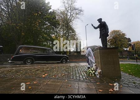 Le cortège funéraire de l'ancien juge-arbitre Harold 'Dickie' Bird, décédé en septembre à l'âge de 92 ans, passe devant sa statue de bronze grandeur nature, alors qu'elle se dirige vers son service funéraire à l'église St Mary's voisine, à Barnsley. Date de la photo : dimanche 19 octobre 2025. Banque D'Images