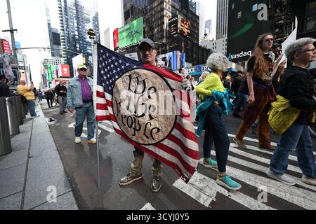 Jonathan de New York brandit un drapeau avec « We the People » pendant les « No Kings protestations » à Times Square à New York, New York, samedi 18 octobre 2025. (Photo : Gordon Donovan) Banque D'Images