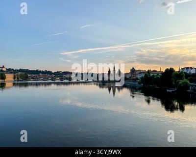 Vue calme en soirée sur la rivière Vltava vers les tours historiques et les toits du centre de Prague, République tchèque. Banque D'Images