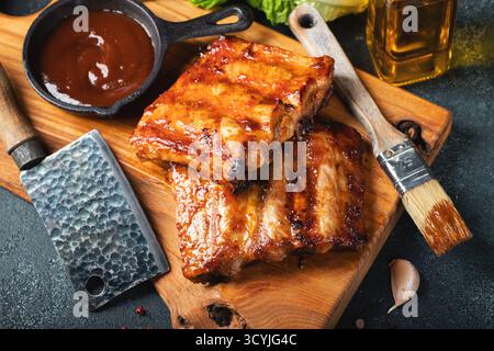 Côtes de rechange grillées chaudes épicées d'un barbecue d'été servies avec un piment chaud et des tomates fraîches Banque D'Images