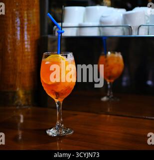 Aperol spritz dans un verre à vin avec des tranches d'orange et des glaçons à l'intérieur. Sur une terrasse d'un café de la ville, Minsk, Biélorussie. Verdure en arrière-plan,. Photo de haute qualité Banque D'Images