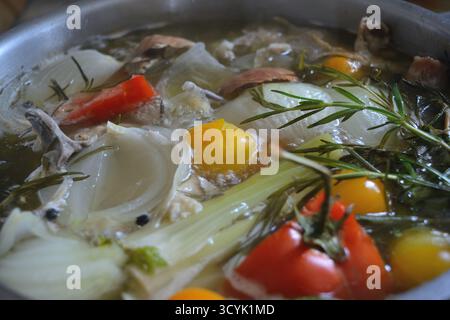 Gros plan du bouillon d'os riche ou du bouillon imbibé d'herbes et de légumes Banque D'Images