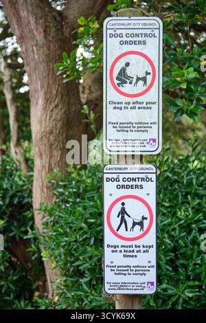 Des panneaux de contrôle des chiens émis par le conseil municipal de Canterbury rappellent aux propriétaires de nettoyer les déchets et de garder les chiens en laisse en tout temps dans les lieux publics Banque D'Images