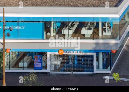 Une vue surélevée et à angle élevé d'un magasin d'électronique Coolblue à Arnhem, mettant en valeur son image de marque bleue moderne, ses grandes fenêtres et son affichage intérieur. Arnh Banque D'Images