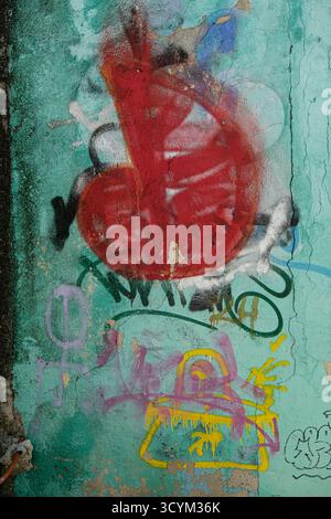 Murale graffiti urbaine vibrante avec des formes abstraites et des couleurs vives sur un mur texturé Banque D'Images